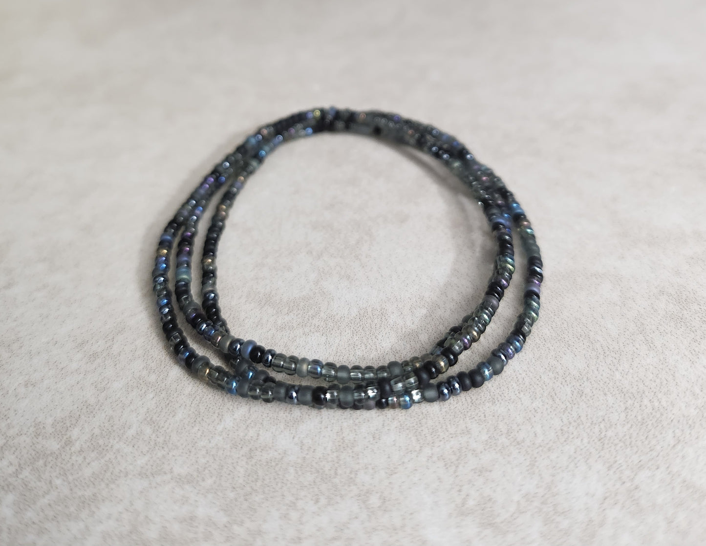 11/0 Midnight Set of 3 Tiny Stretch Stackable Seed bead bracelet set, shades of black, dark grey, and dark purple/blue iris hue.